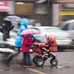 Mother walking in rain stroller