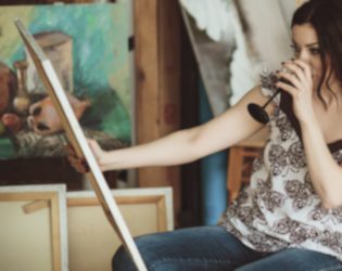 woman drinking wine and painting