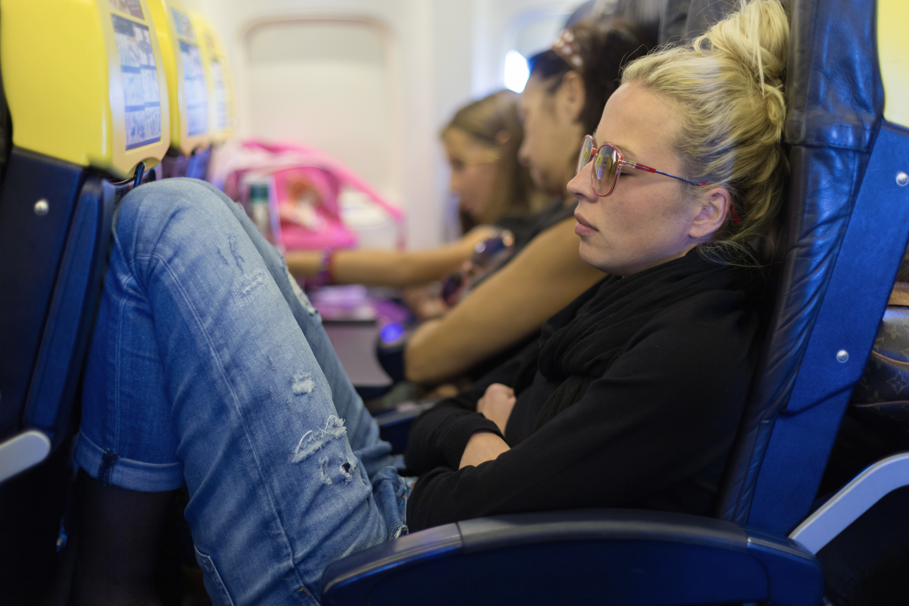 Люди сидят в самолете. Самолет с пассажиром. Девушка в самолете. Спать в самолете. Неудобные кресла в самолете.